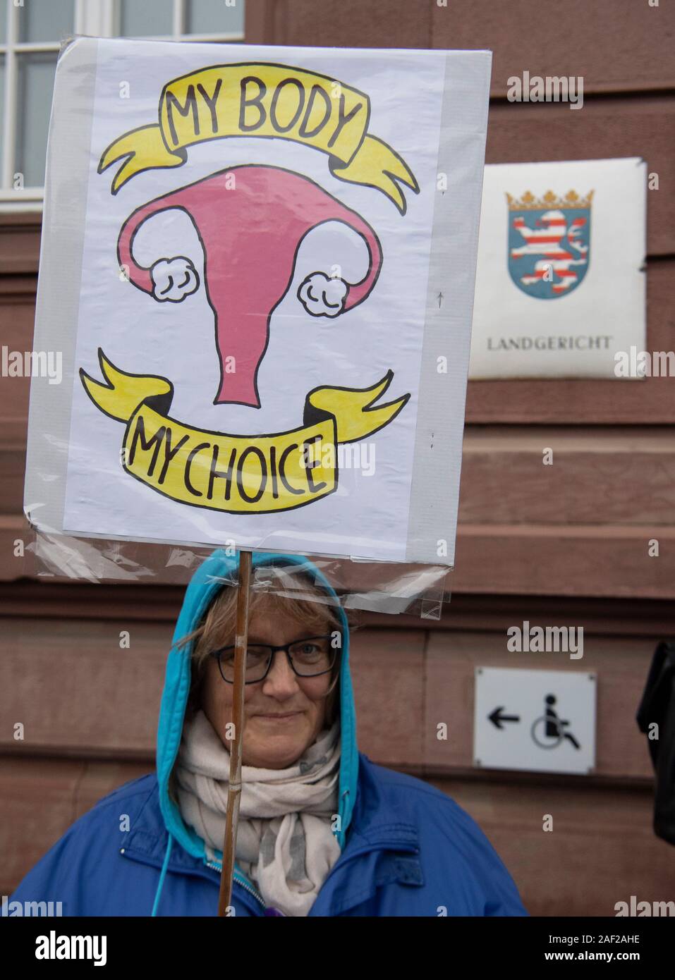 12 December 2019, Hessen, Gießen: 'My body, my choice' is on a poster that this woman uses to support gynaecologist Hänel. The regional court pouring concerns itself again with the question whether the lady doctor against the controversial abortion paragraph 219a offended. The public prosecutor's office accuses Hänel of having offered abortions as a service on its website and thus violated the law. Photo: Boris Roessler/dpa Stock Photo