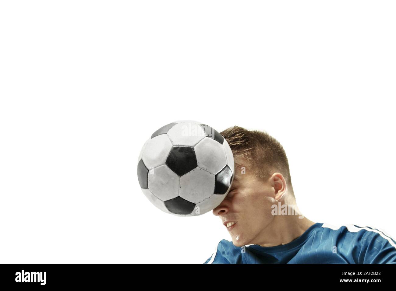 Close up of emotional caucasian man playing soccer hitting the ball