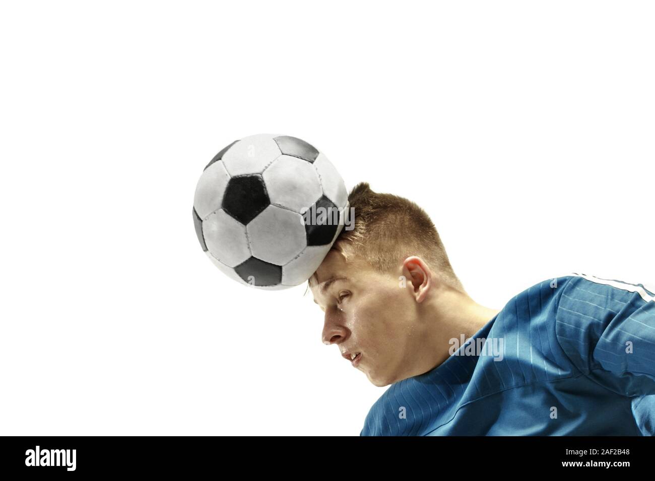 Close up of emotional caucasian man playing soccer hitting the ball