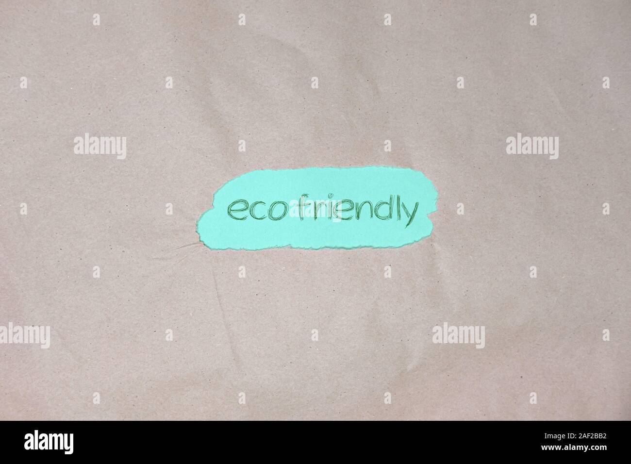 "eco friendly" text on and brown green packing paper background. Stock Photo