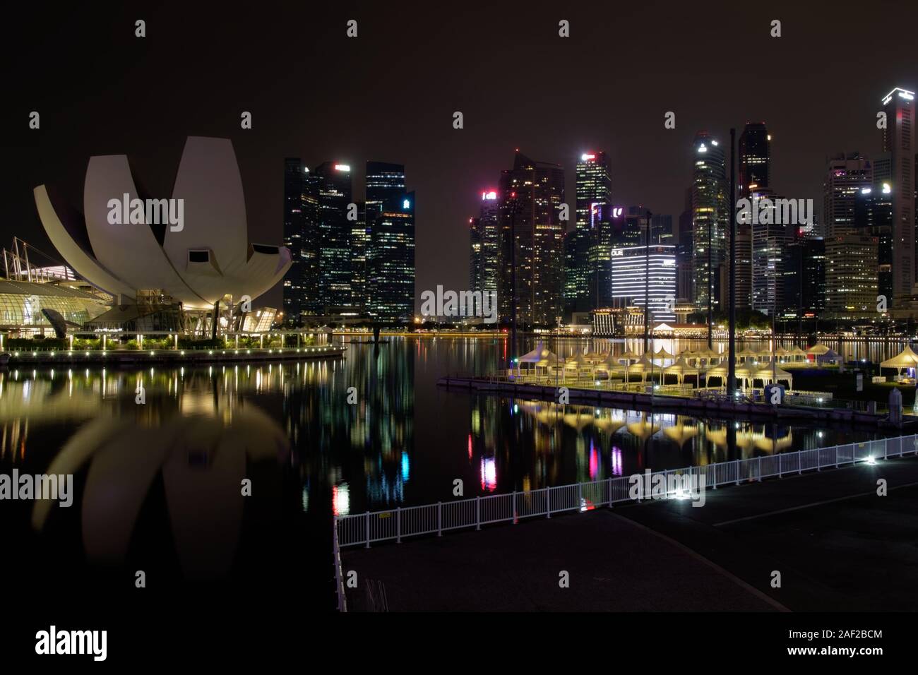 Panorama of Marina Bay water reflection colours at night, with viewpoint lotos flower shape building and skyscrapers in background Stock Photo