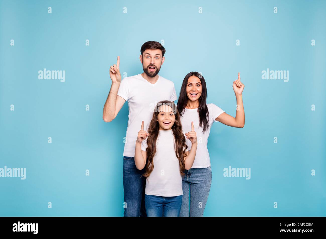 Portrait of excited funky three people promoters mom dad schoolkid with brown hair recommend sales ads select up ways wear white t-shirt denim jeans Stock Photo