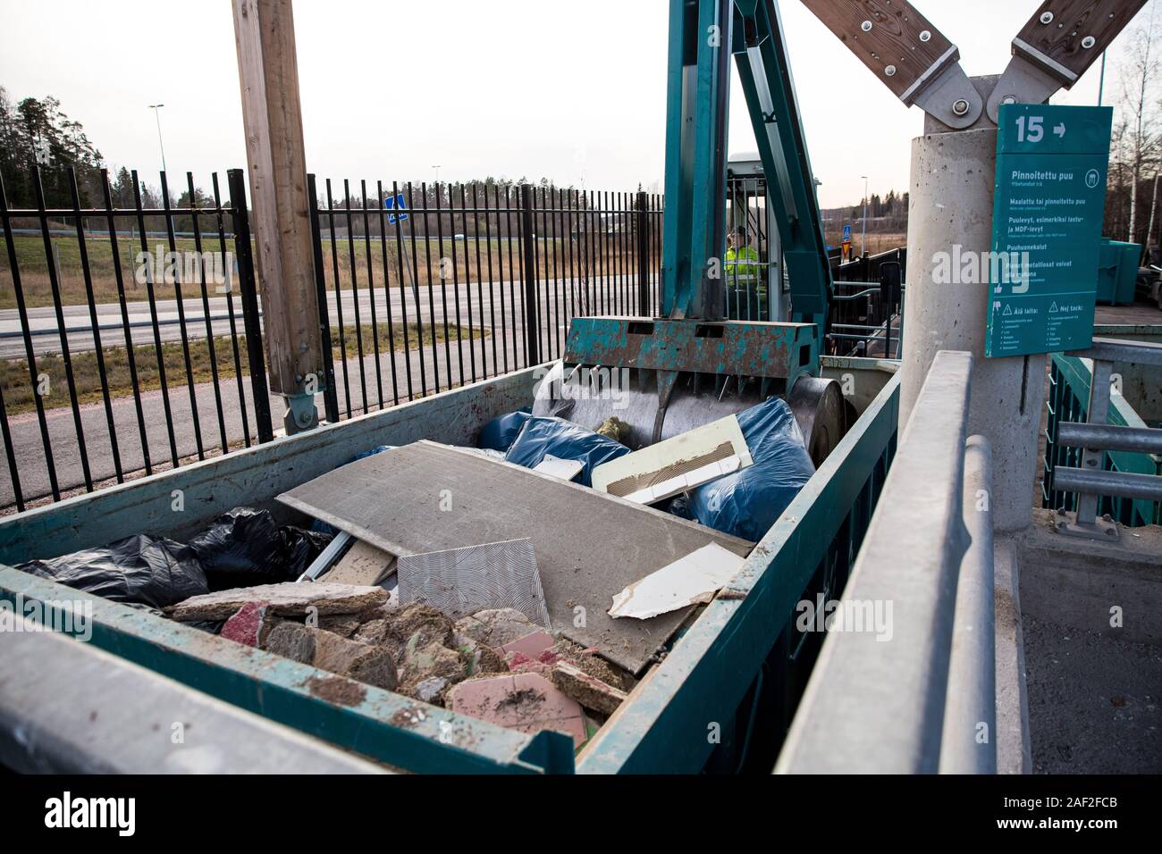 Sorting station HSY - center for sorting, safe disposal and recycling of waste. Special equipment is pressing construction waste in a container Stock Photo