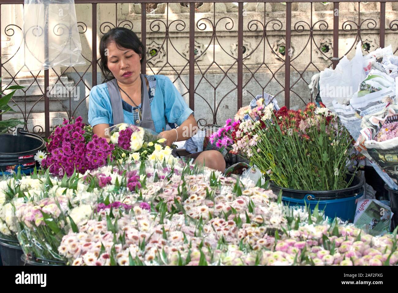BANGKOK, THAILAND-OCTOBER 26TH 2013: A woman prepares flowers for sale at Bangkok's flower market (Pak Khlong Talat). The market is the biggest wholes Stock Photo