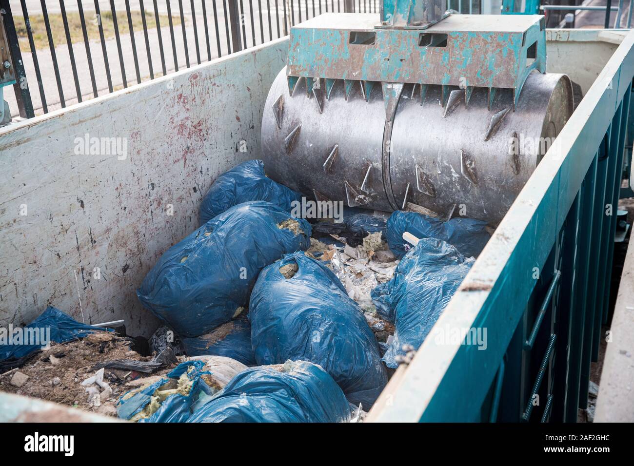 Special equipment is pressing construction waste in a container for recycling in Sorting station Stock Photo