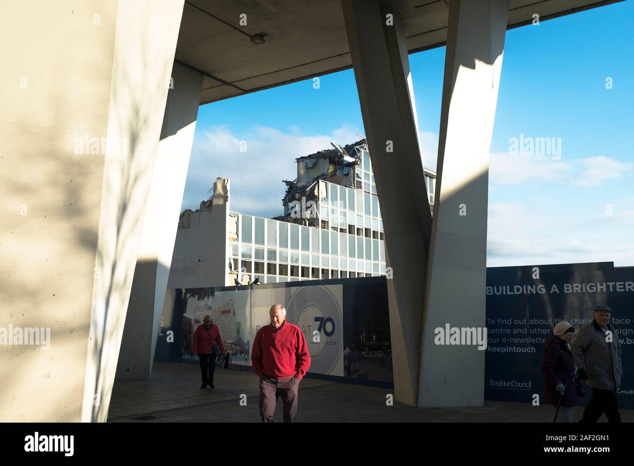 People walking past the site of the old Post Office building being demolished as part of the long awaited redevelopment of Basildon Town centre in Ess Stock Photo