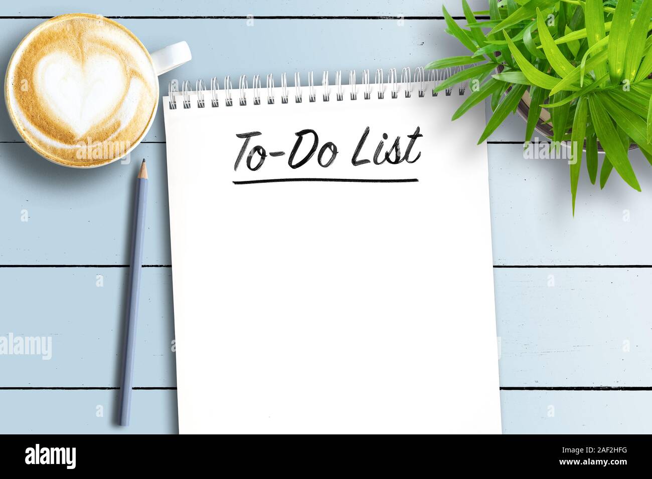 top view of spiral bound notebook with To-Do List on white wooden table with potted plant and cup of coffee Stock Photo