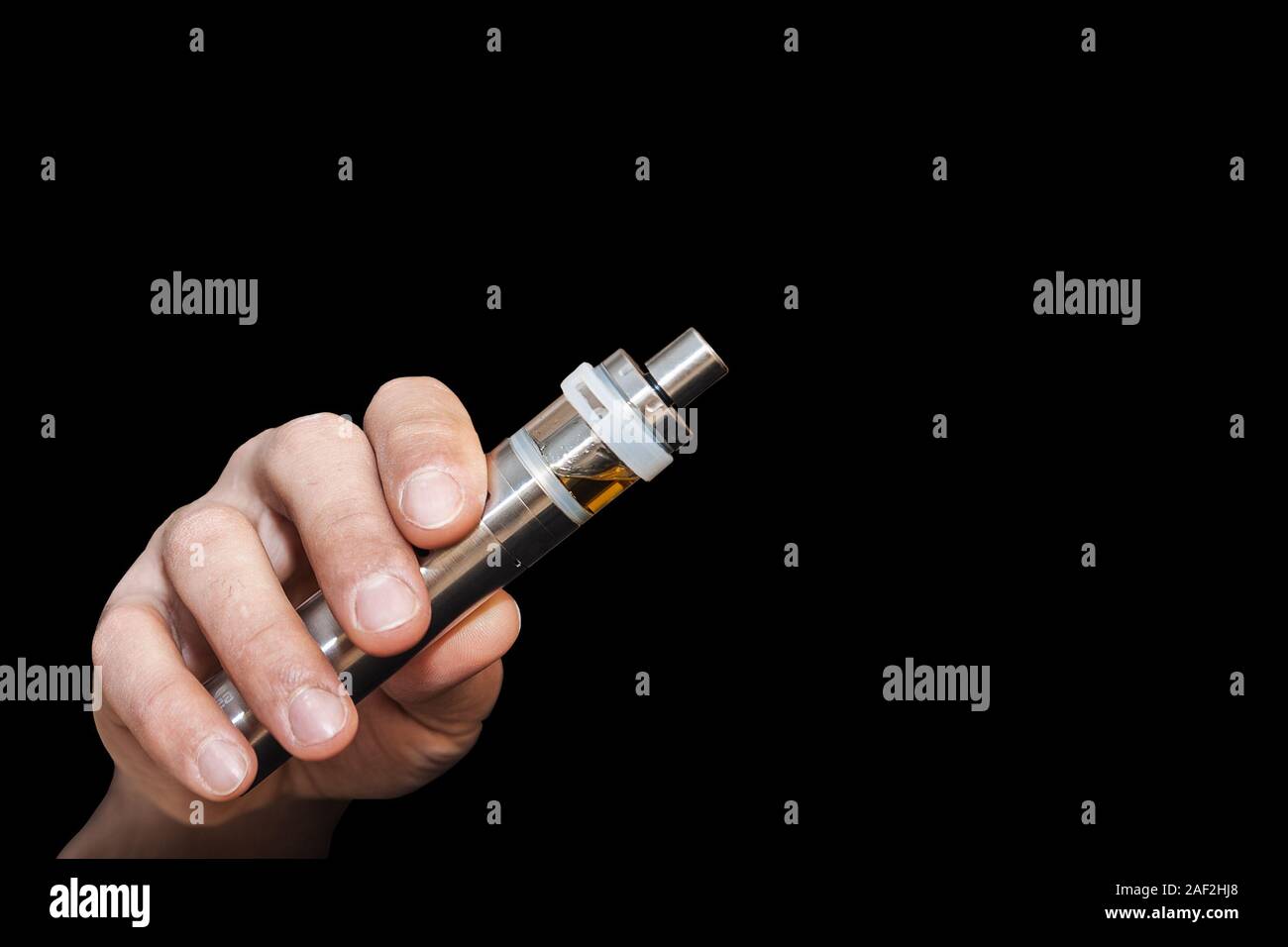 A man's hand holds an electronic cigarette. Ban electronic cigarettes. Harm to health