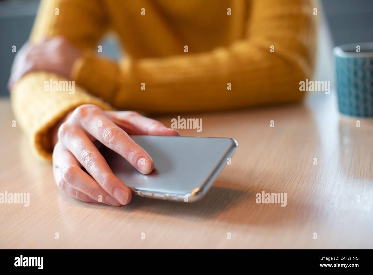 Woman Concerned About Excessive Use Of Social Media Laying Mobile Phone Down On Table Stock Photo