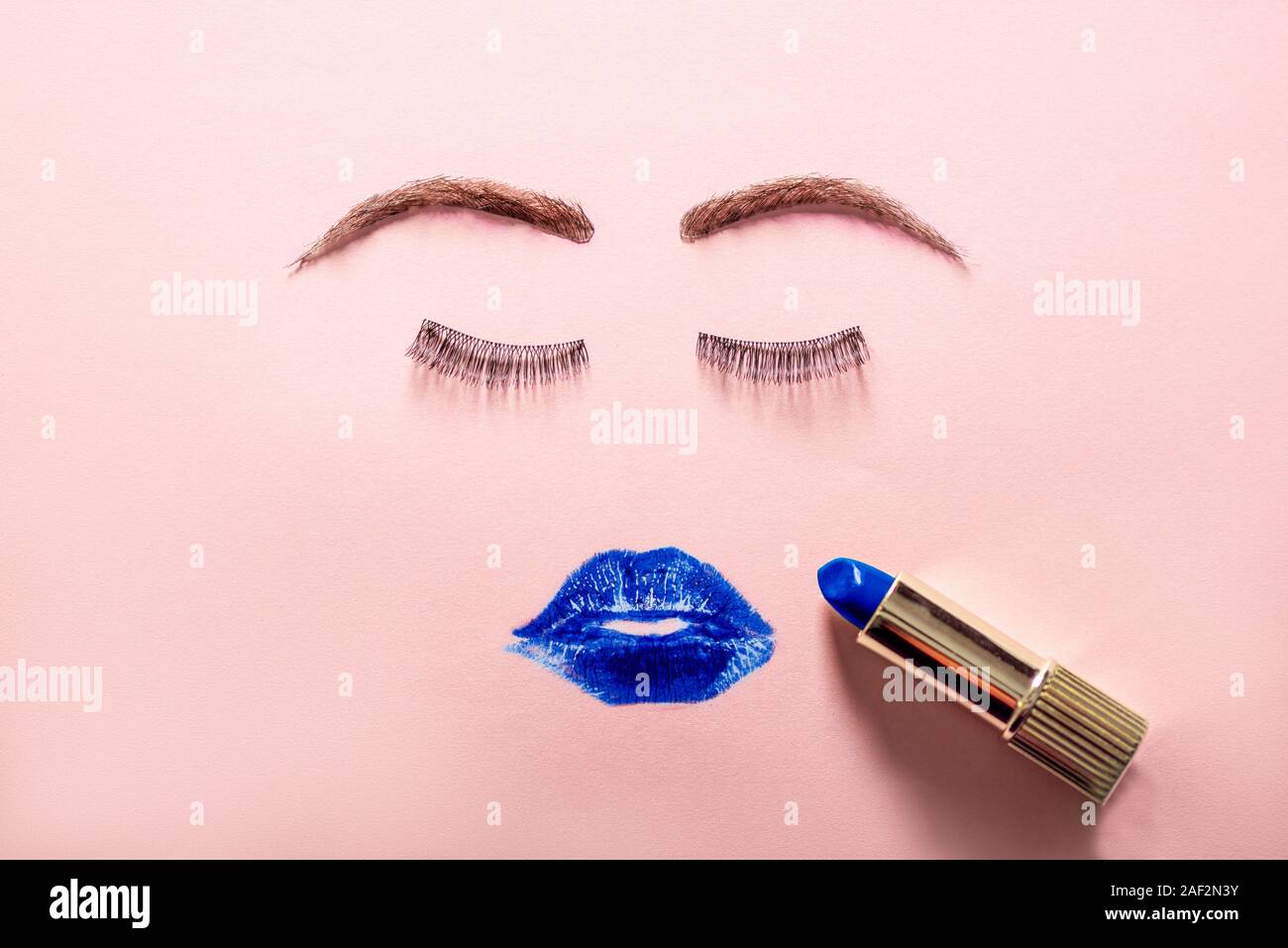 Creative woman face made of eyelashes, wig eyebrows and blue lipstick