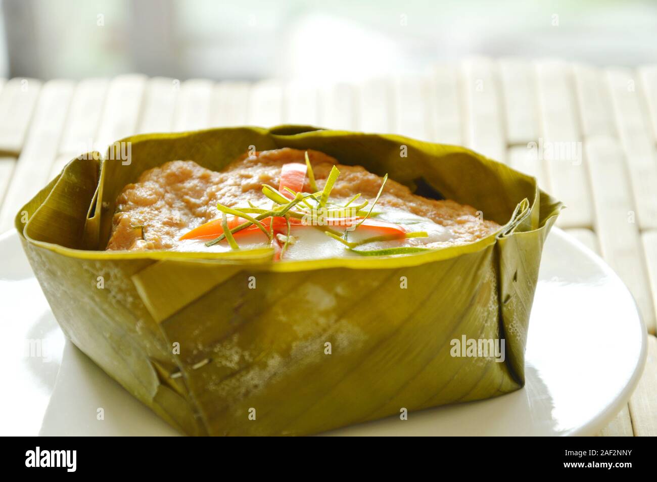 steamed fish with curry paste stuffed Indian mulberry in coconut milk on banana leaf cup Stock