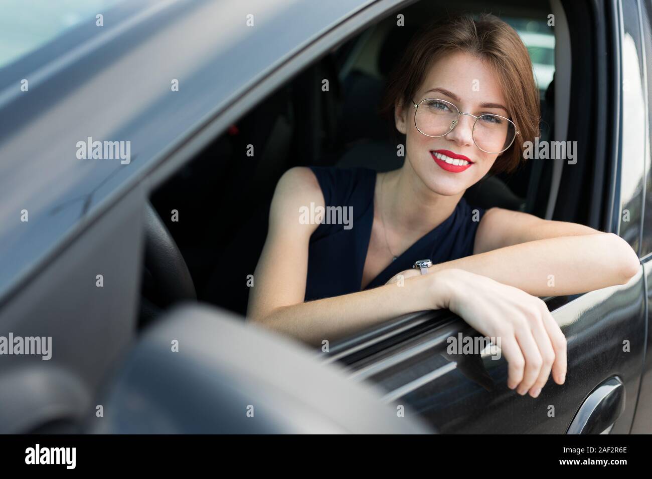 Beautiful girl in strict style of clothing gets out of the car for an ...