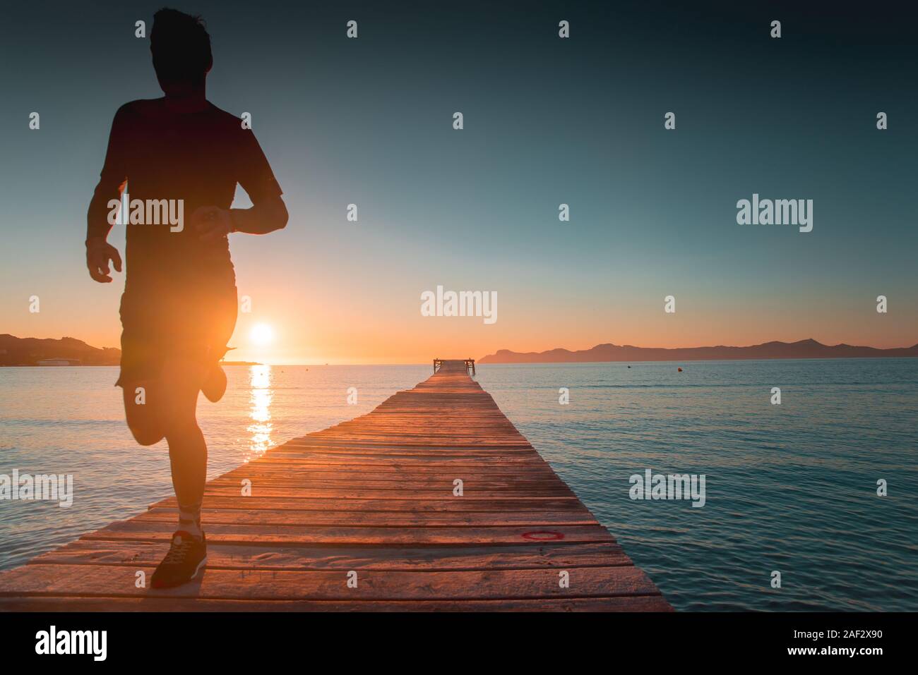 Runner silhouette by the sea in morning Stock Photo