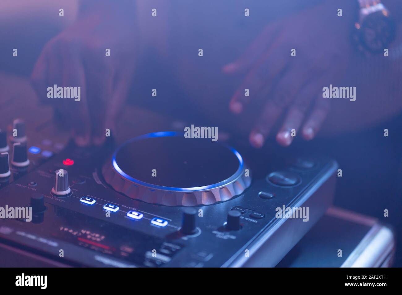 club dj plays music on stage in of disc jockey adjusting