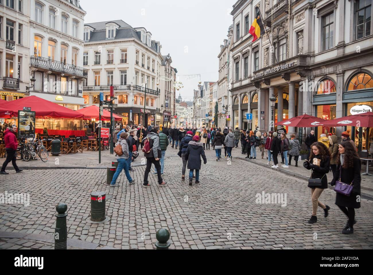 People strolling along a cobblestone street decorated for Christmas in the historic Brussels old town Stock Photo