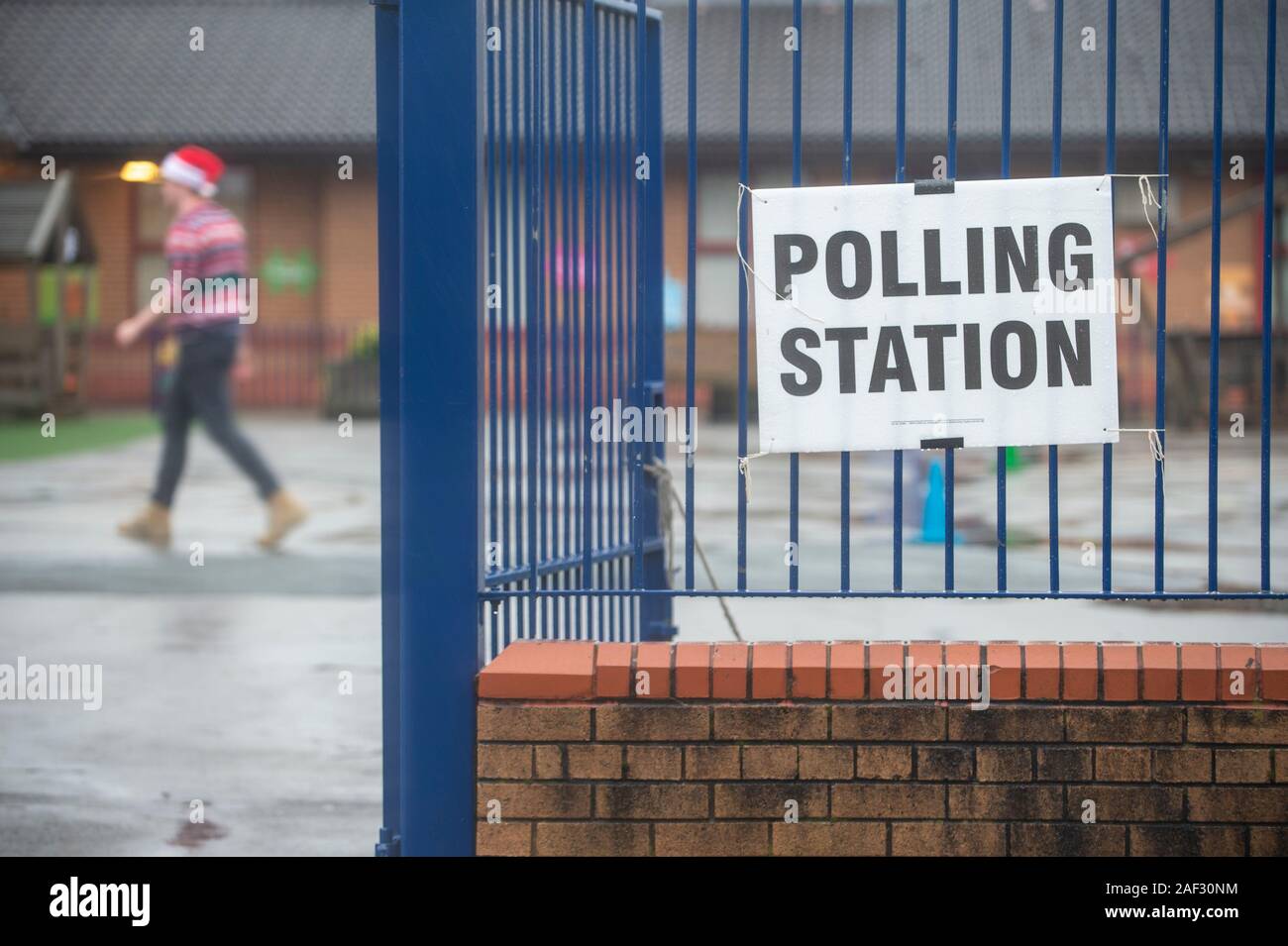 Stoke-on-Trent, UK. 12 December 2019. A voter takes a selfie outside a polling station while wearing a santa hat and christmas jumper in the rain. Stoke-on-Trent central is a key General Election battleground for both Labour and Conservatives. [EDITORIAL NOTE: Male shown in photograph did not provide name but consented to photo being used for editorial usage] Credit: Benjamin Wareing/ Alamy Live News Stock Photo