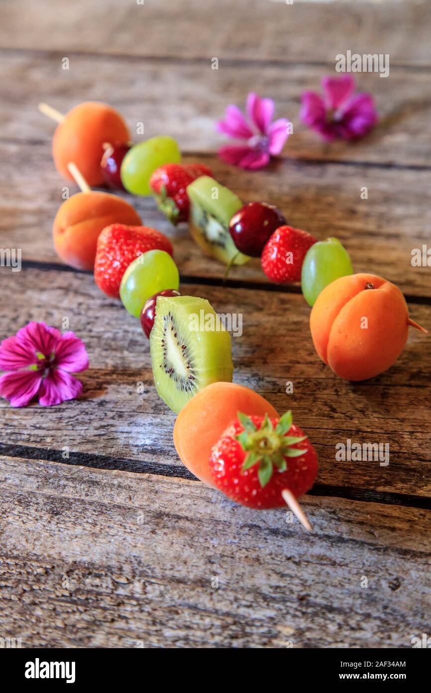 Fresh fruit kebabs on a wooden table Stock Photo