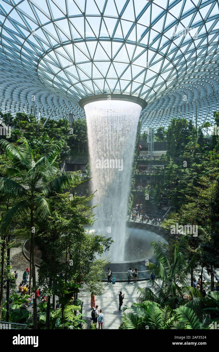 Singapore - Dec 10, 2019: Changi Rain Vortex as largest and tallest indoor waterfall in world at the center of Jewel Changi Airport that connecting te Stock Photo