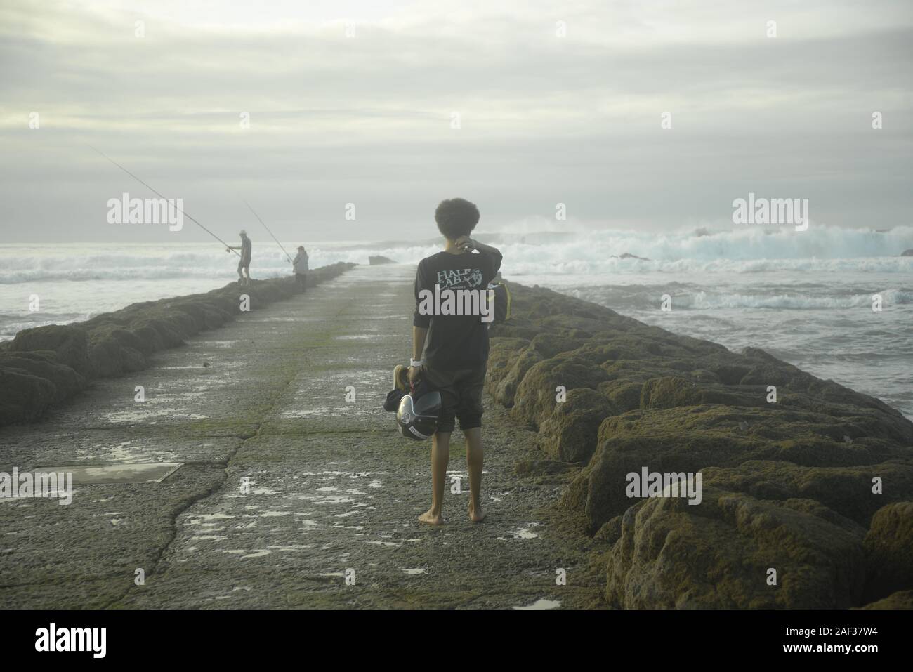Barefoot young man looking out to sea, pasakdek Stock Photo - Alamy
