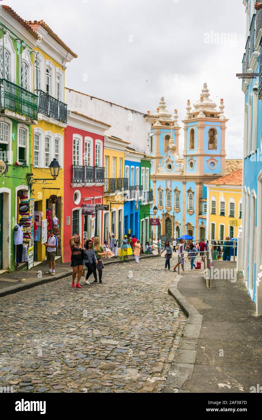 Colonial buildings and tourists taking selfies at Pelourinho - Church of Our Lady of the Rosary of the Black People in the background Stock Photo