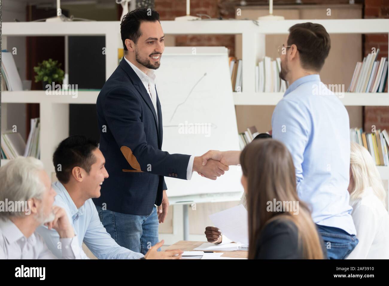Multi racial businessmen shaking hands closing deal Stock Photo