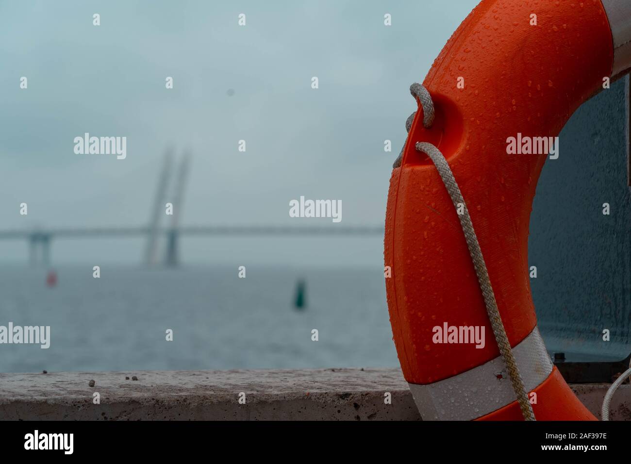 View on Cable-stayed Big Bridge Over the River in Saint Petersburg. Russia Through Lifebuoy. Bridge is on Background and Blurred, Orange Lifebuoy Is o Stock Photo