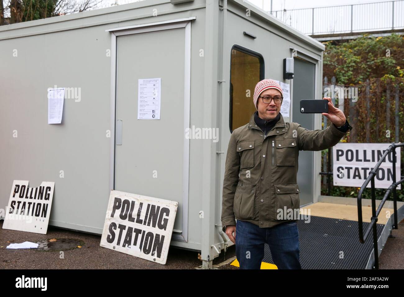 A voter takes a selfie outside a cabin used as a Polling Station after voting in the UK General Election in Haringey, north London.Polling stations across the country opened at 7am and will close at 10pm in the first December election since 1923. Stock Photo