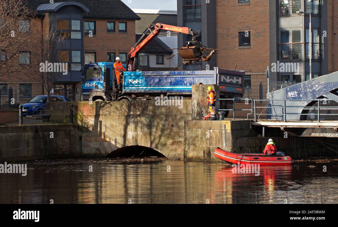 Leith, Edinburgh, Scotland, UK. 12 December 2019. 5 weeks and 6 days after #SOSLeith's well attended public meeting, the long overdue clean-up of Water of Leith Basin 1 has finally begun. A new clean-up strategy to tackle the build-up of debris in the Water of Leith basins at the Shore has begun with a joint agreement by the Council, Forthports & Water of Leith Conservation Trust. Stock Photo