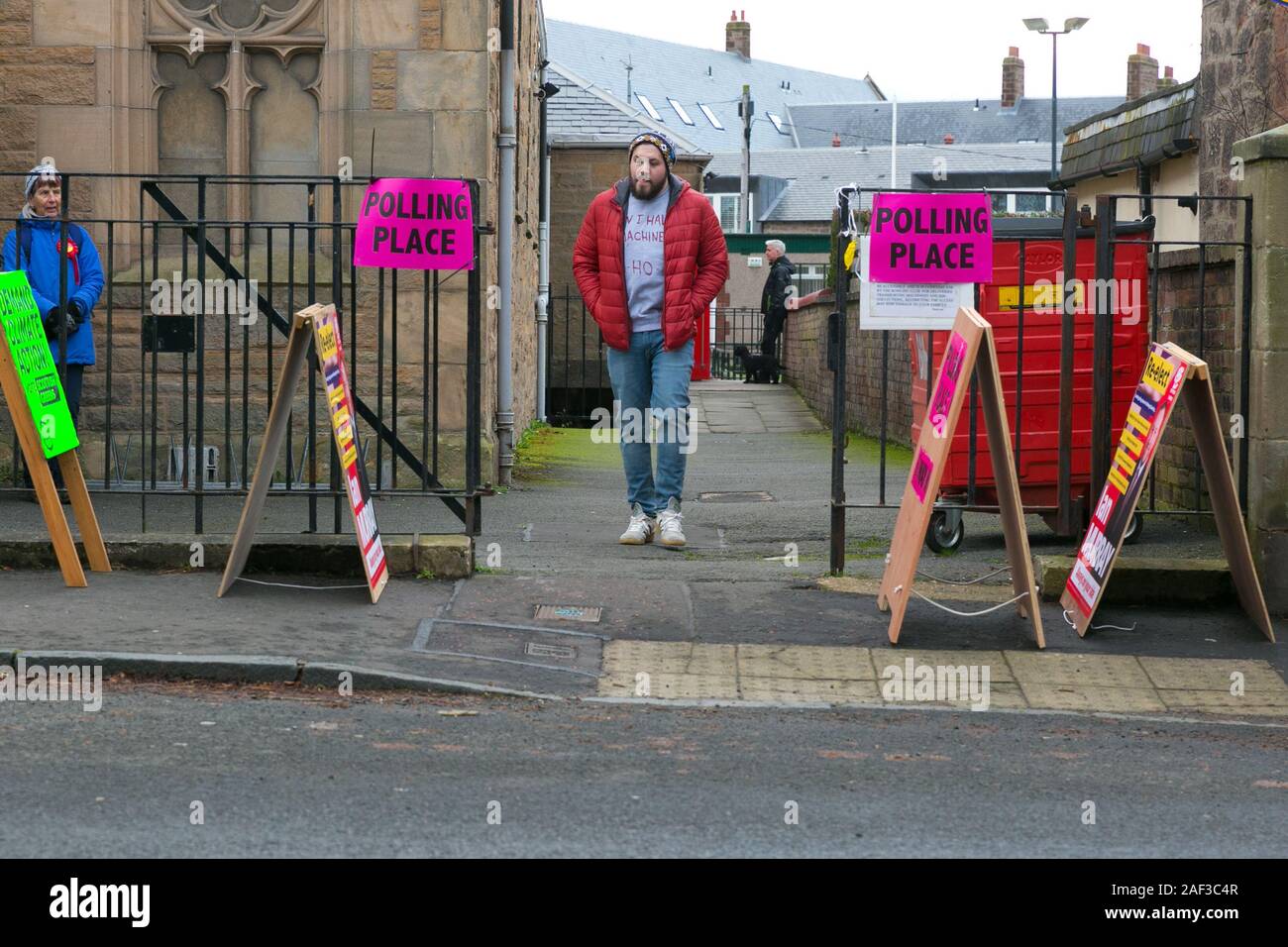 Edinburgh, Scotland, 12th December 2019. A single man exits the polling station after casting his vote in the UK's winter General Election. Laour and SNP activists look on. Credit: Brian Wilson/Alamy Live News. Stock Photo