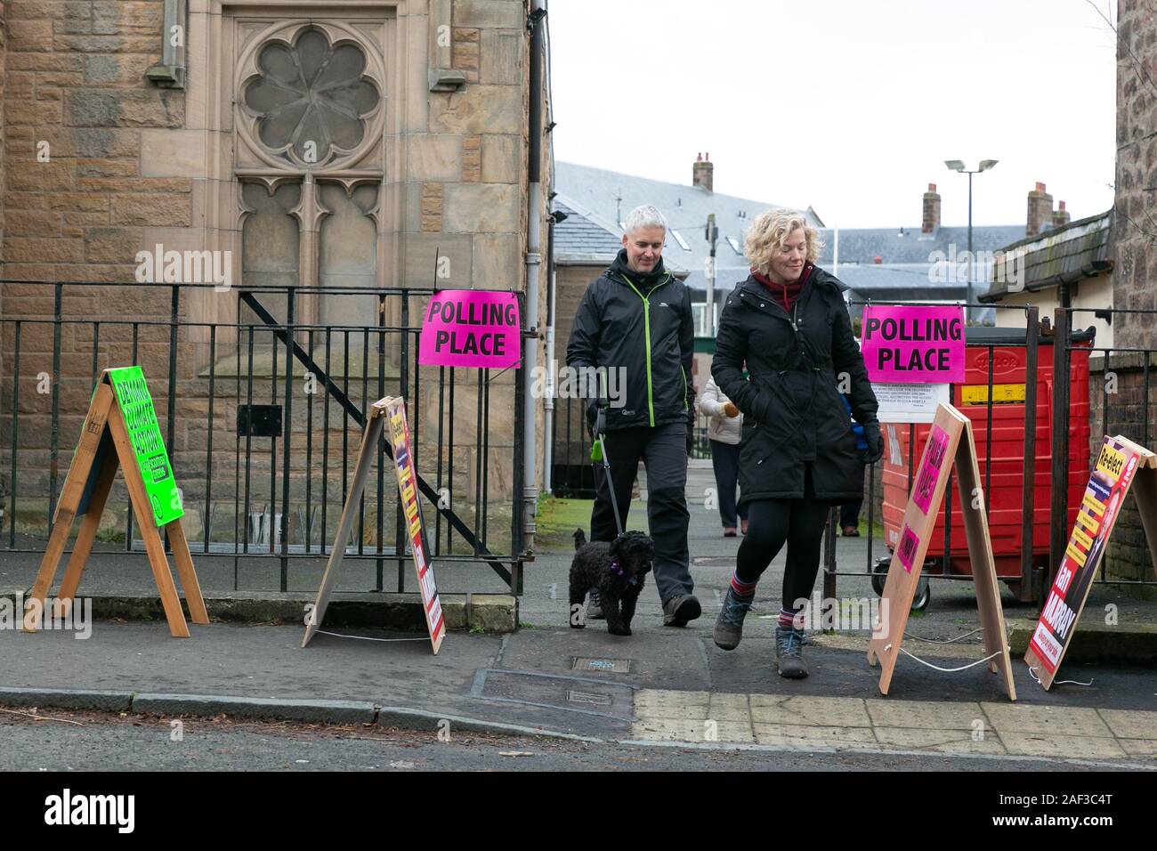 Edinburgh, Scotland, 12th December 2019. A middle-aged couple with a dog exit the polling station after casting their votes in the UK's winter General Election. Credit: Brian Wilson/Alamy Live News. Stock Photo