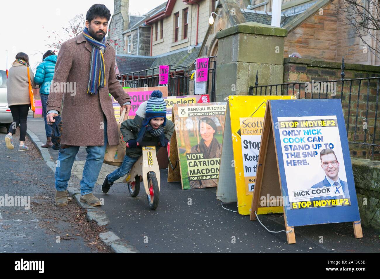 Edinburgh, Scotland, 12th December 2019. A father has cast his vote for a candidate at the UK's winter General Election. His young son isn't interested. Credit: Brian Wilson/Alamy Live News. Stock Photo