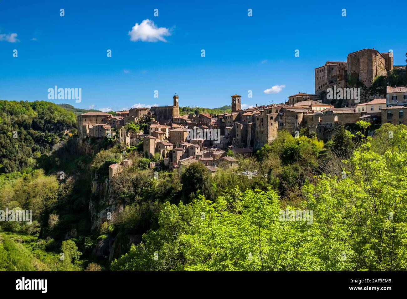 The medieval town is located at the end of a wooded valley, the stone walls of the Fortezza Orsini overtopping the houses Stock Photo