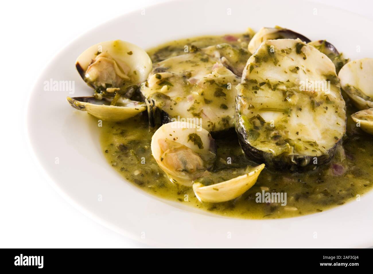 Hake fish and clams with green sauce isolated on white background