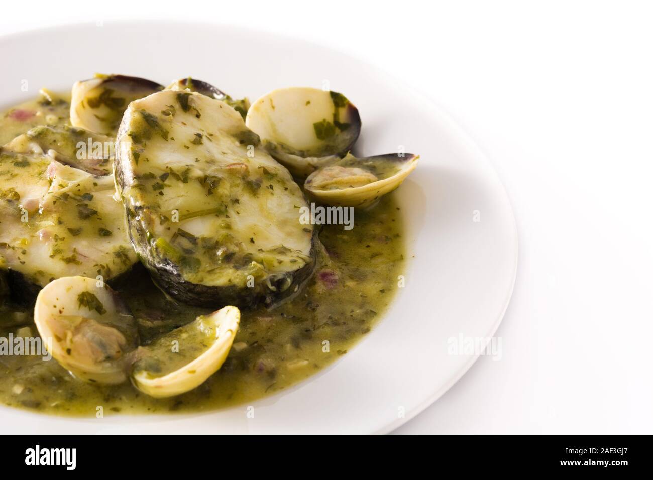 Hake fish and clams with green sauce isolated on white background