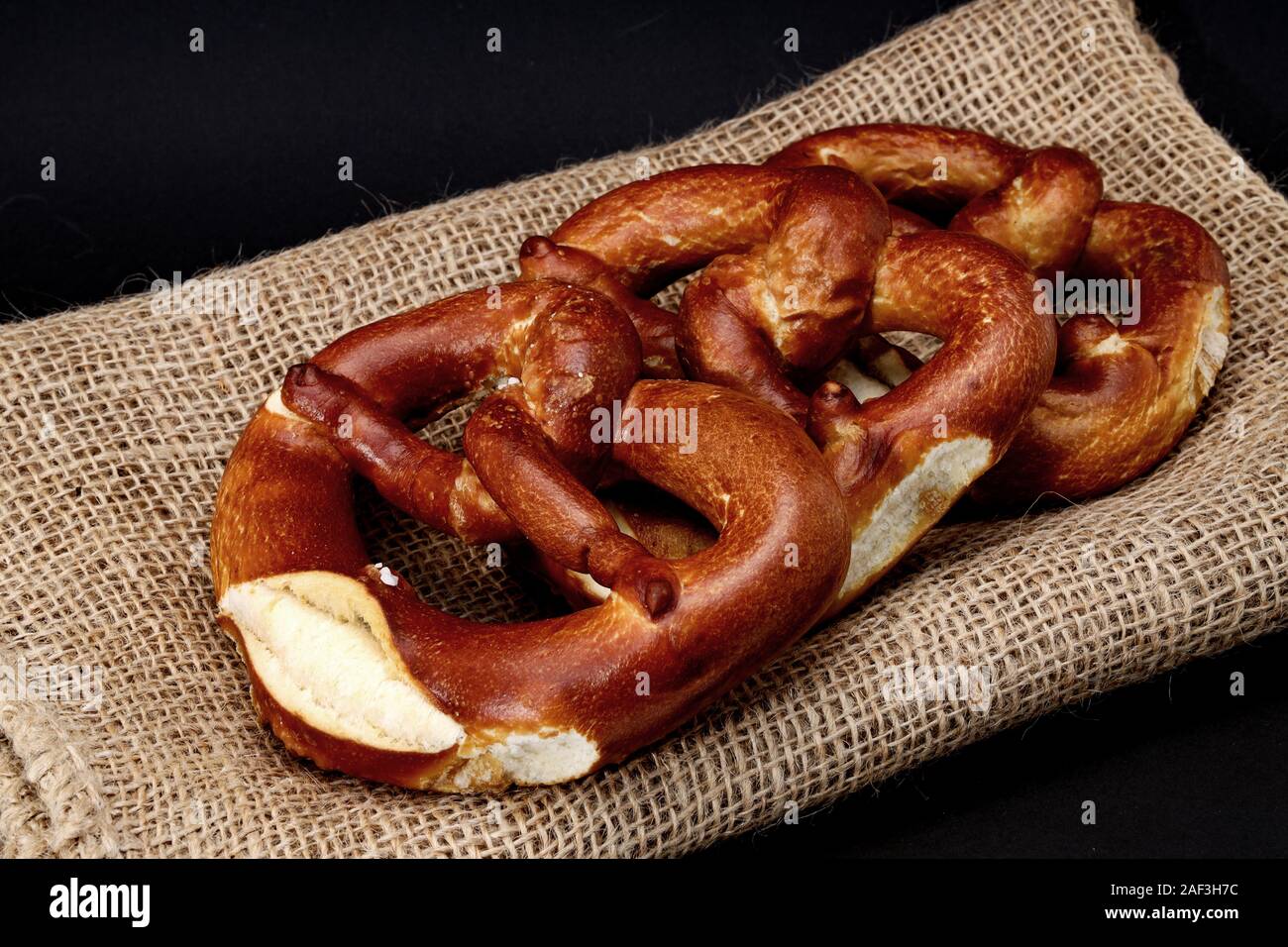 Pretzels on a hessian place mat - black background Stock Photo