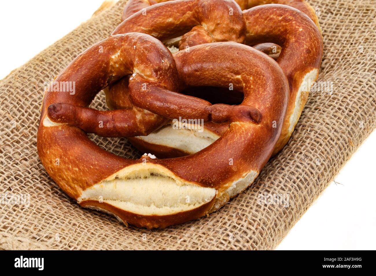 Pretzels on a hessian place mat - white  background Stock Photo