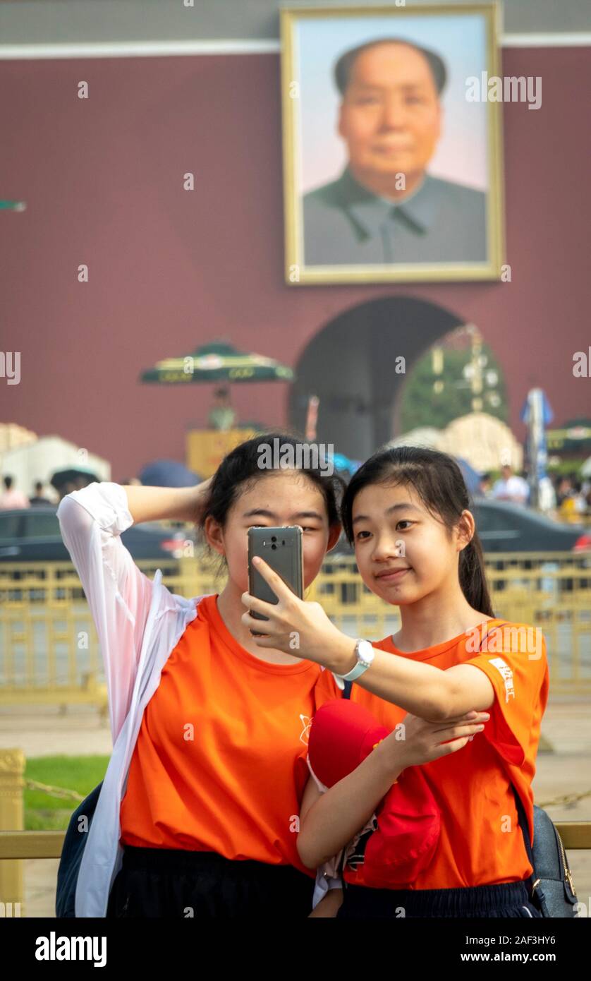 schoolchildren taking selfies on on field trip to Tiananmen Square and Forbidden City, Beijing, China Stock Photo