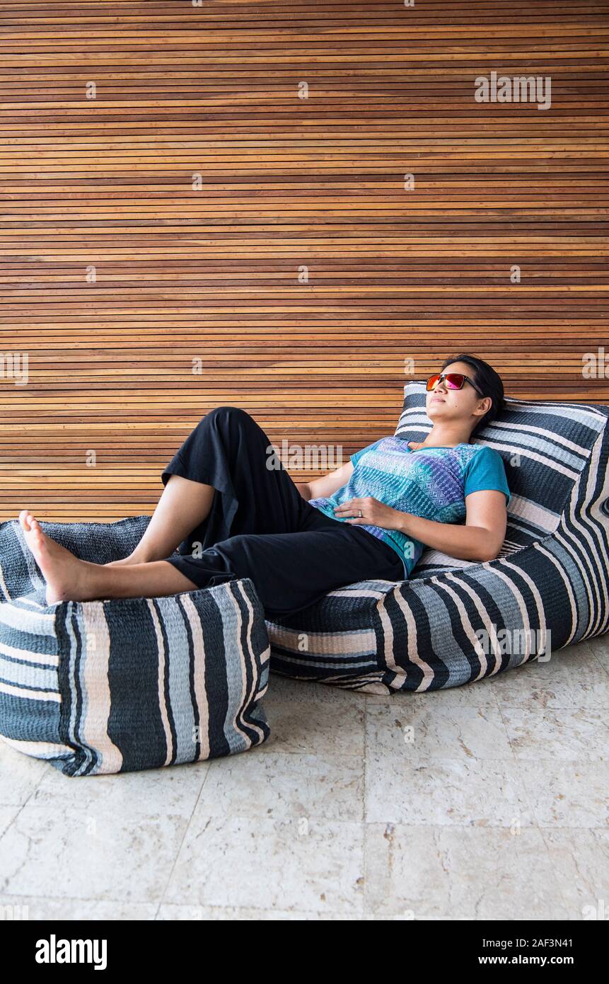 Woman relaxing on comfortable pillow sofa Stock Photo