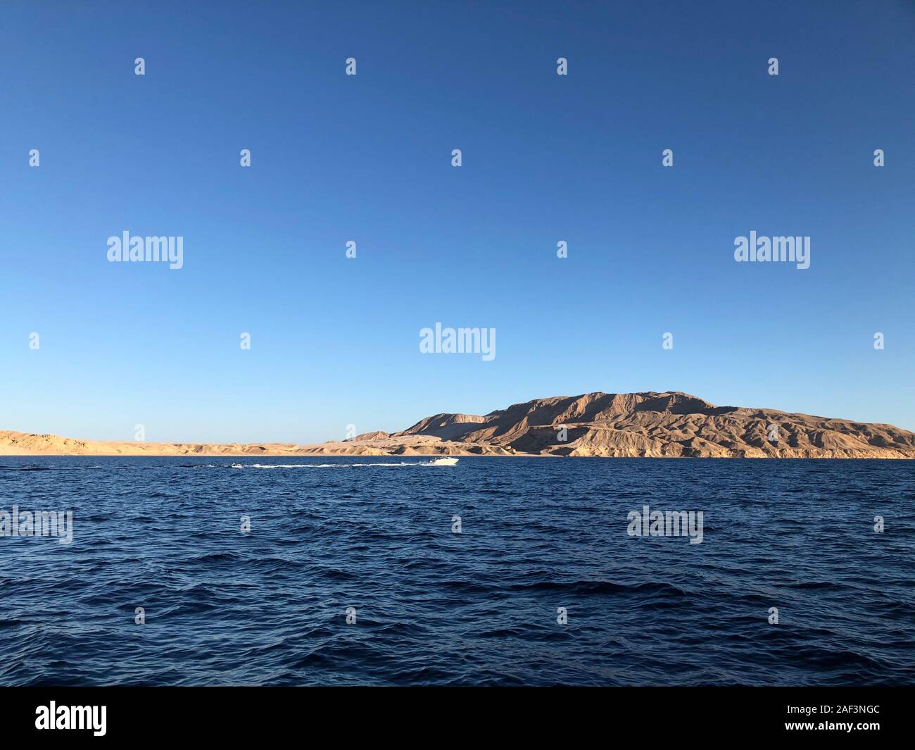 Landscape of tropical ocean with Tiran island on turquoise ocean waves, blue sky. Picture of vacation and travel to Egypt. A good banner for a tourist Stock Photo