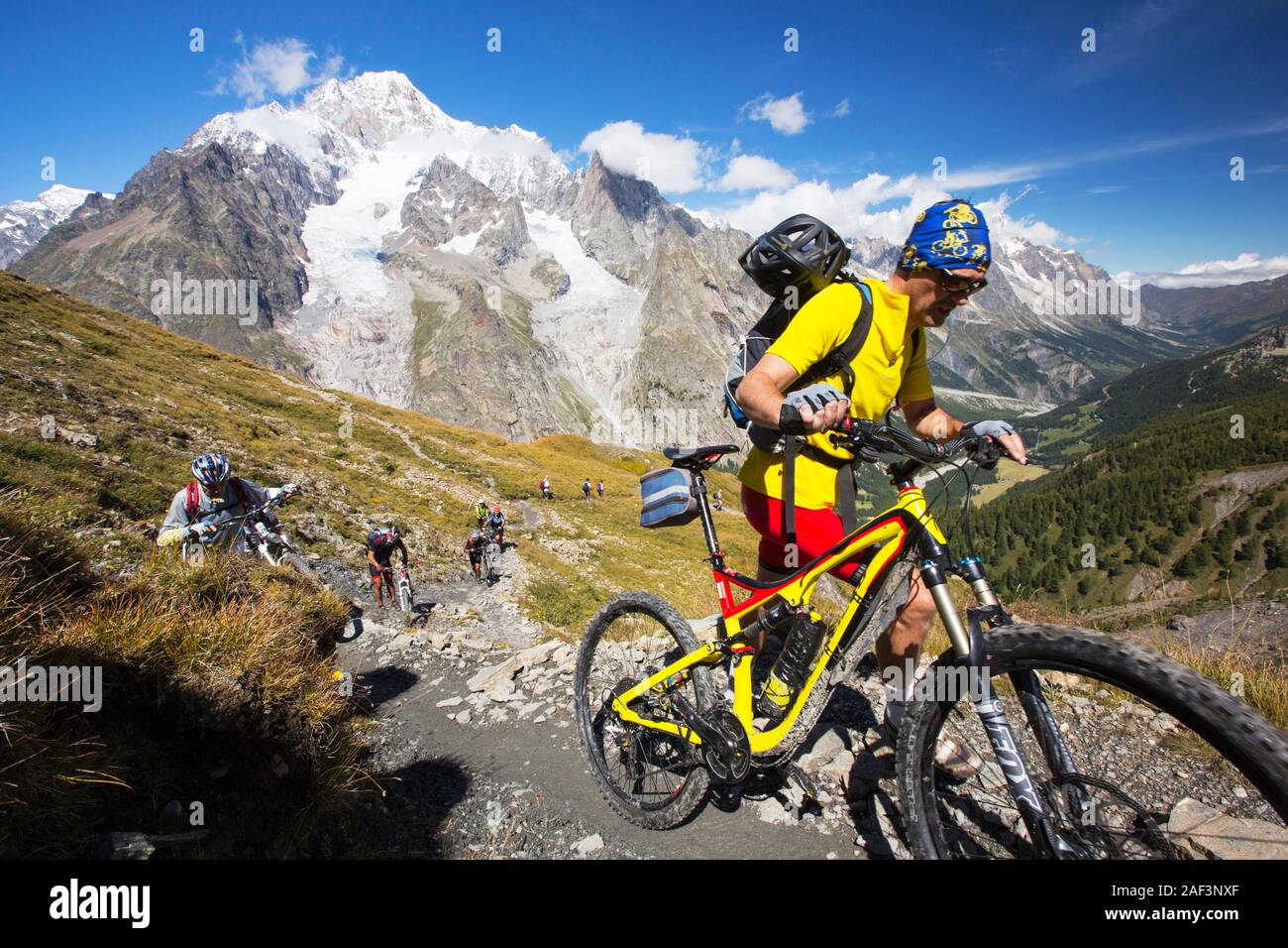 Mountain bikers ascending out of the Vallon de la Lex Blanche in Italy, below Mont Blanc. Stock Photo