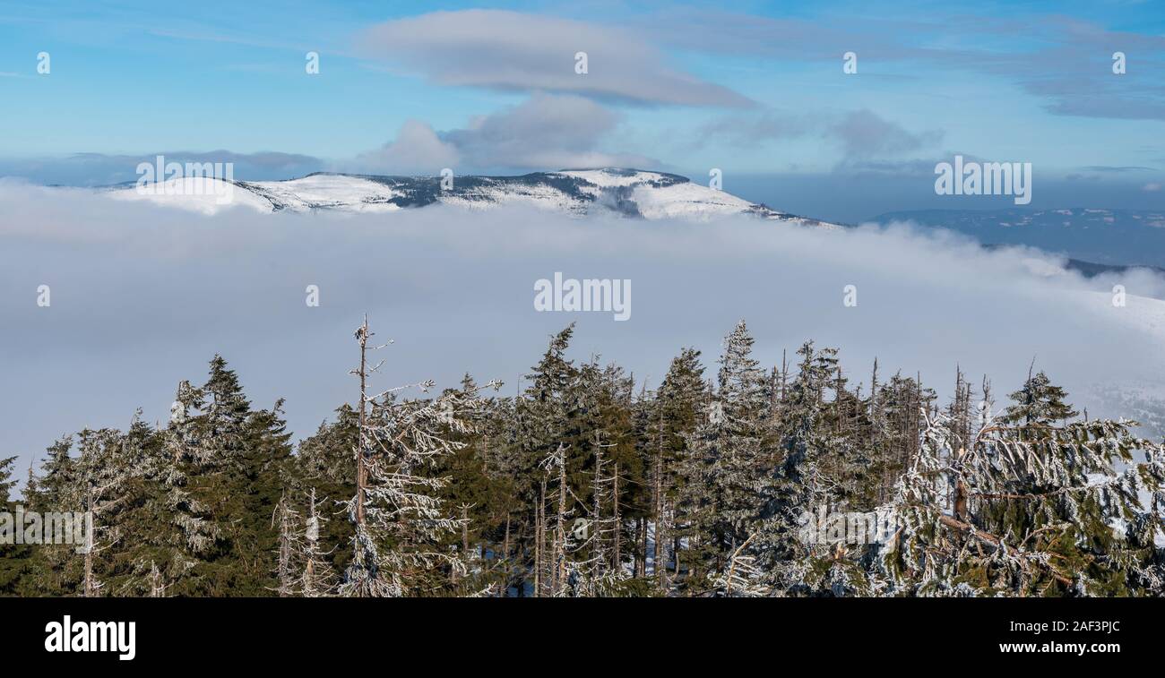 Skrzyczne, Male Skrzyczne and Kopa Skrzyczenska from Barania Gora hill in Beskid Slaski mountains in Poland during winter day with mist and blue sky w Stock Photo