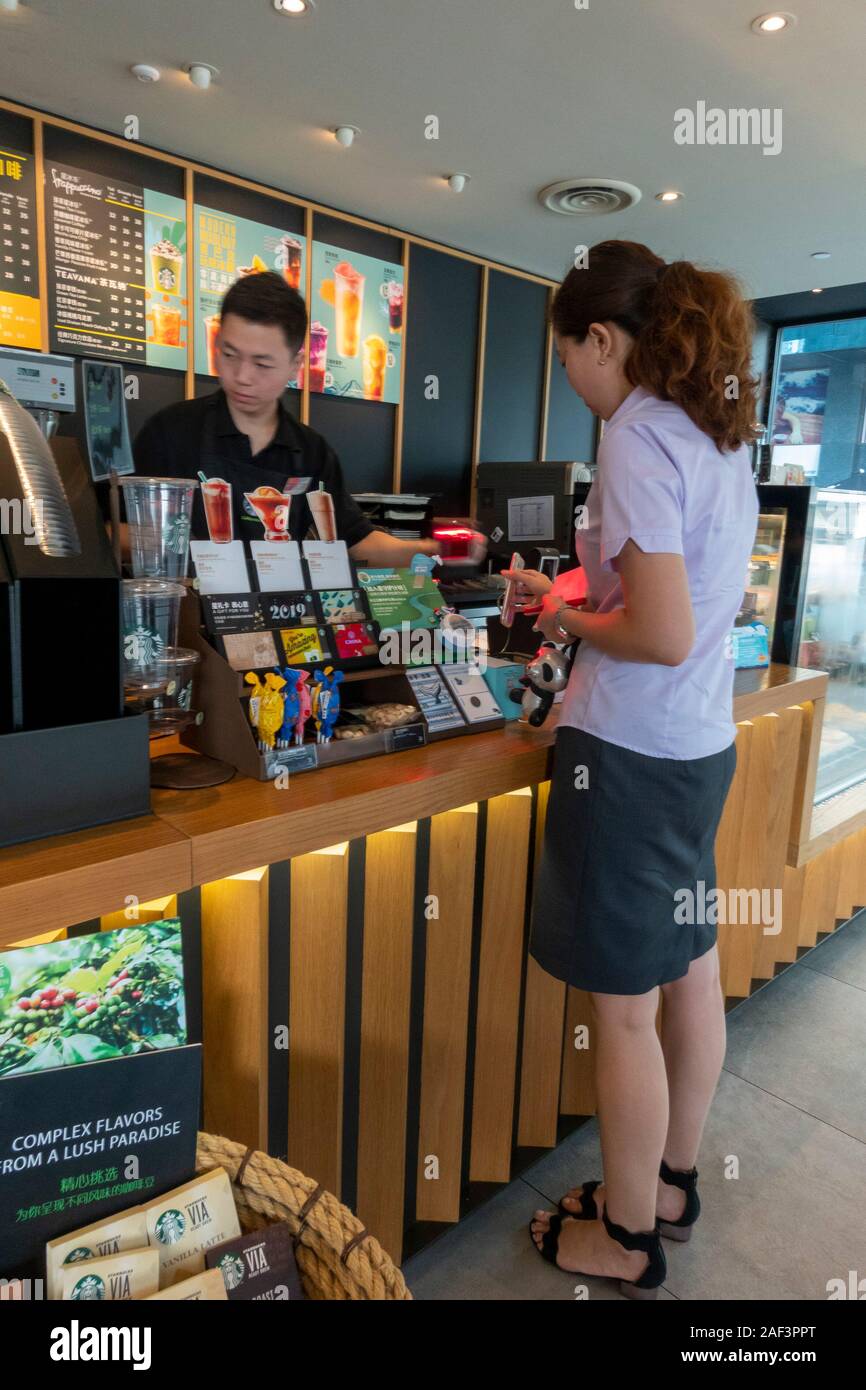 customers paying by contactless cell phone, Starbucks coffee shop, Xian, China Stock Photo
