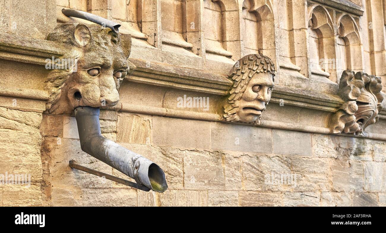 Grotesque Rain Rain gutter and grotesque stone heads on an outside wall of Oxford ...