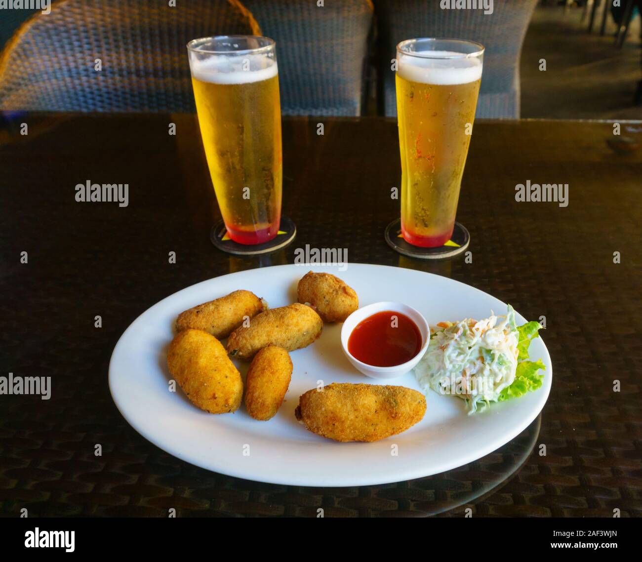 Chilled beer and fried cheese balls served in a restaurant locate in Church Street, Bangalore (India) Stock Photo