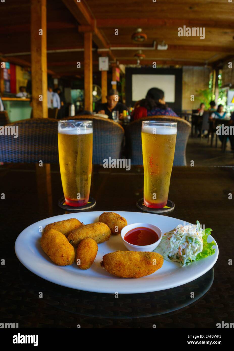Chilled beer and fried cheese balls served in a restaurant locate in Church Street, Bangalore (India) Stock Photo