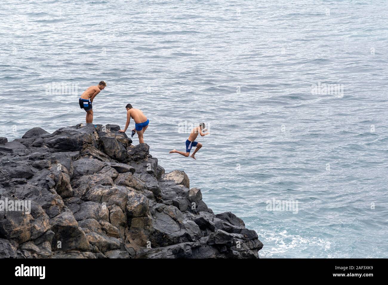 Las Palmas, Gran Canaria, Nov, 2019:  Kids jumping into the ocean near Playa de las Canteras beach,  Las Palmas de Gran Canaria November 2019 Stock Photo
