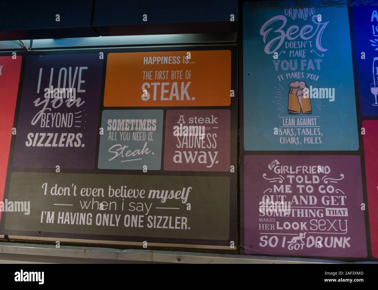 Posters with funny quotes about food, drinks and liqor displayed on the  wall of a restaurant in Bangalore, India Stock Photo - Alamy