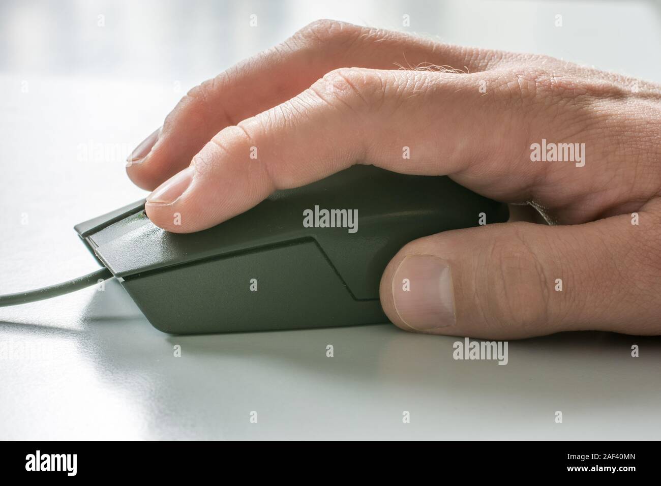 Men hand on computer mouse with white desk in the background Stock ...