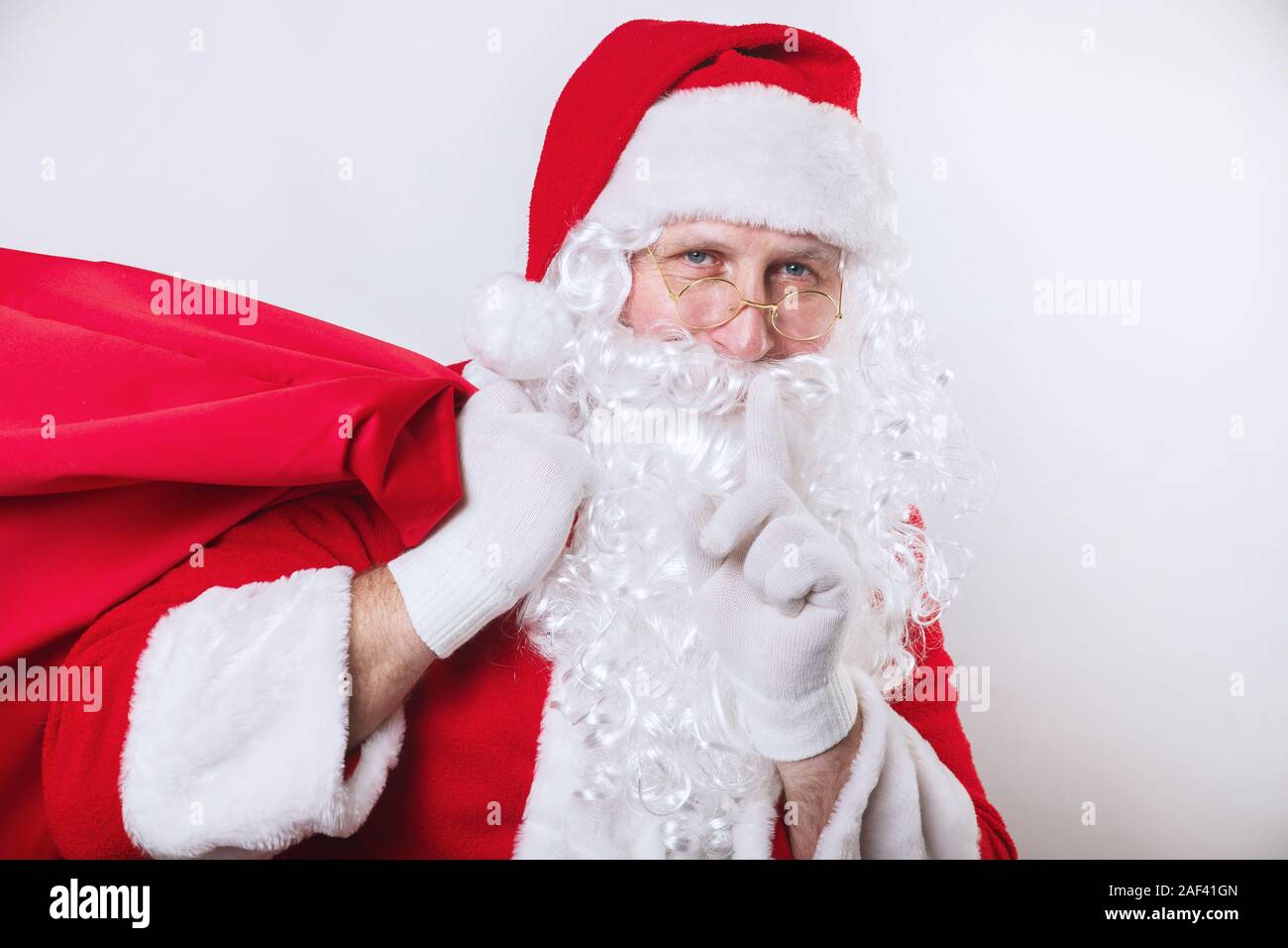 Santa Claus carrying big bag full of gifts on white background Stock ...