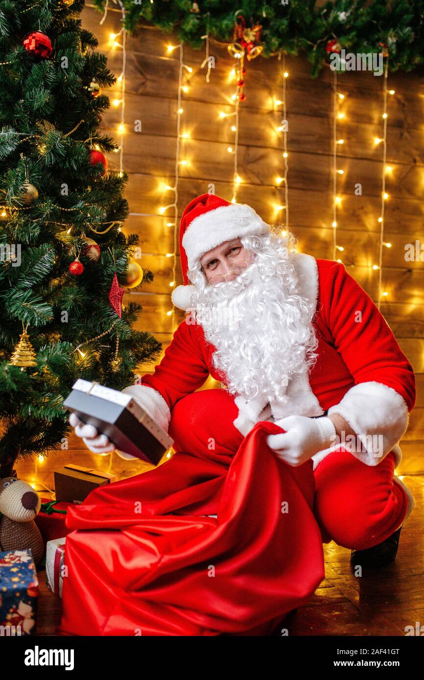 Santa Claus near Christmas tree with gifts. Christmas time Stock Photo